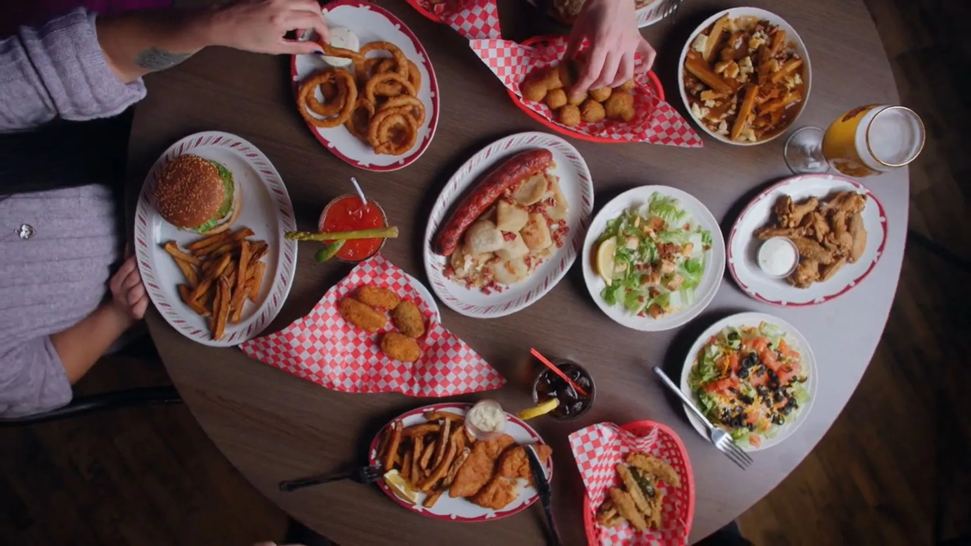 A table covered in Rednex favourites: burgers, wings, salads, nachos and fries
