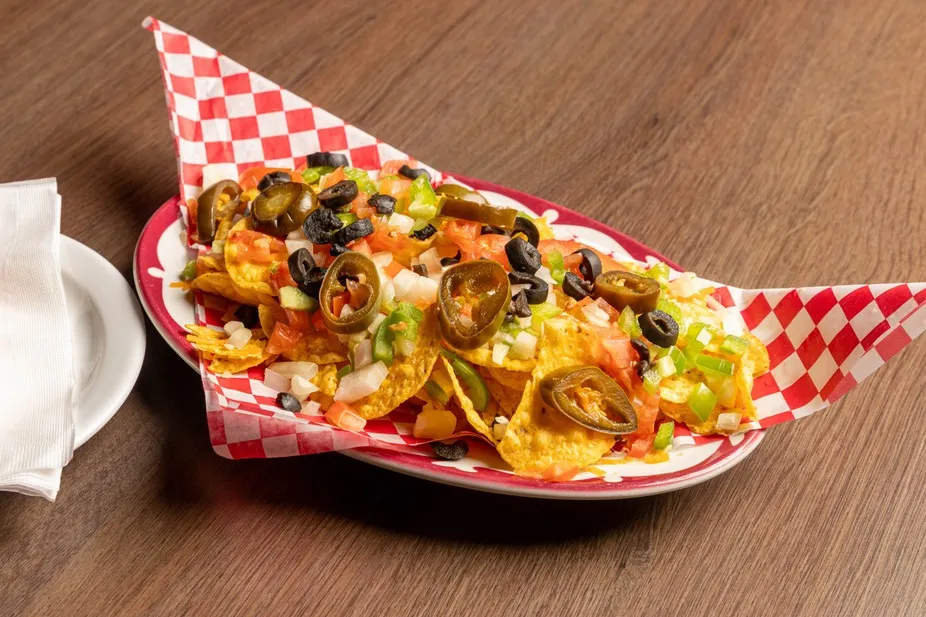 Nachos piled with jalapeños, olives and peppers